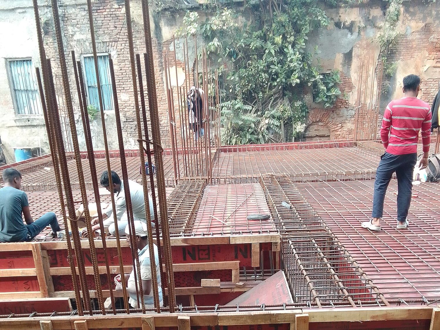 Steel reinforcement and timber formwork in place on a concrete slab before casting. Stand-in photograph.