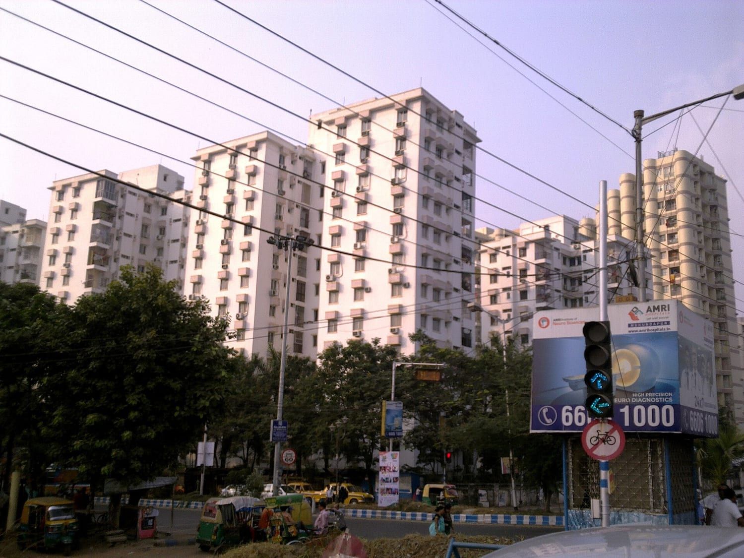 Four-storey residential building with projecting balconies and a mature tree at the kerb. Stand-in photograph.